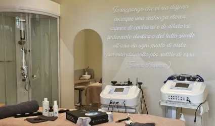 Sala trattamenti viso e corpo Atelier Quinto Elemento Basiglio con tecnologie estetiche e lettino benessere.